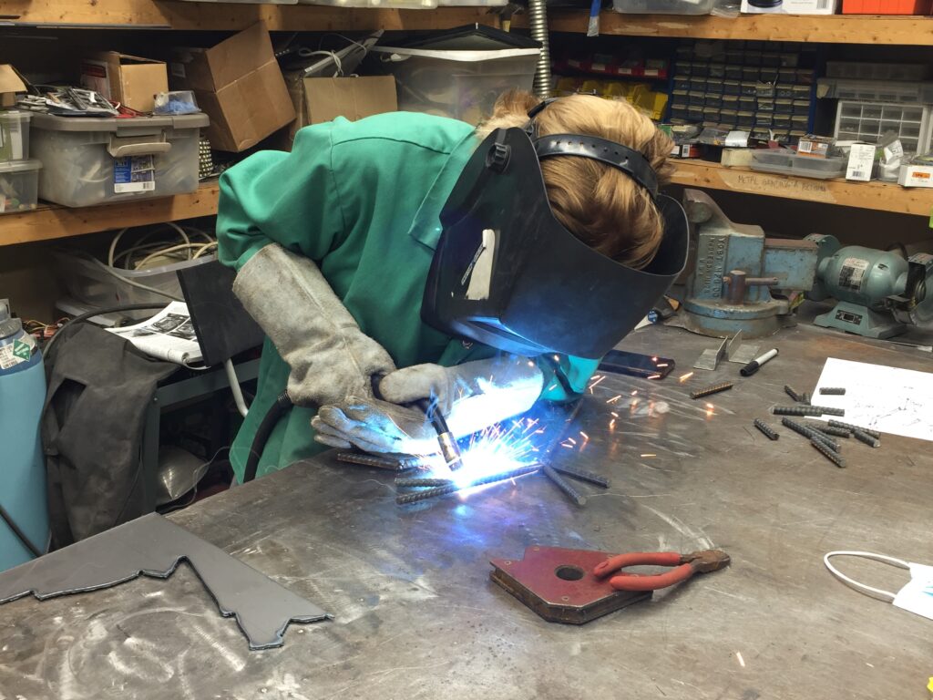 A photograph of a person welding