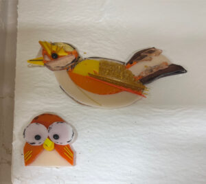 two birds made out of glass, waiting to be fused in the kiln